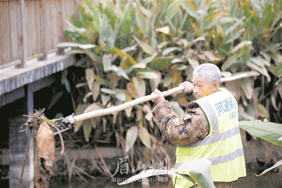 徐雙貴正在打撈河道雜物。.jpg