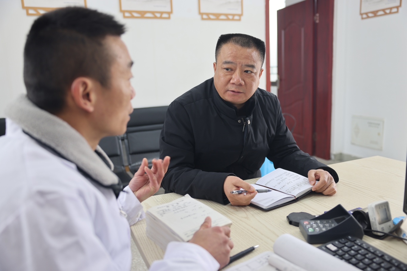 李雪平（右）正和鄉村醫生周良倫開展基層醫療服務的相關討論。